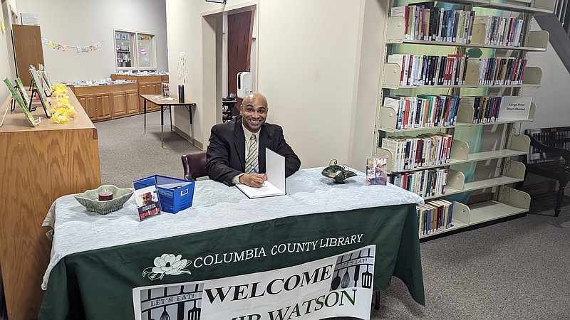 Zhamir Watson signs his cookbook What's Cooking Z? at the Columbia County Library. (Joshua Turner / Banner News)