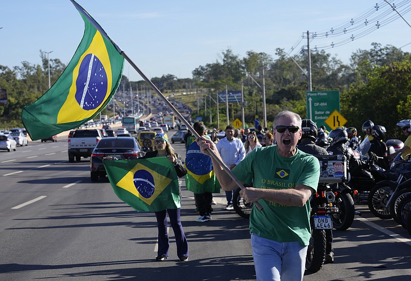 Supporters wait for the arrival of Brazil's Former President Jair Bolsonaro outside the Brasilia International Airport, in Brasilia, Brazil, Thursday, March 30, 2023. Bolsonaro arrived back in Brazil on Thursday after a three-month stay in Florida, seeking a new role on the political scene. (AP Photo/Eraldo Peres)
