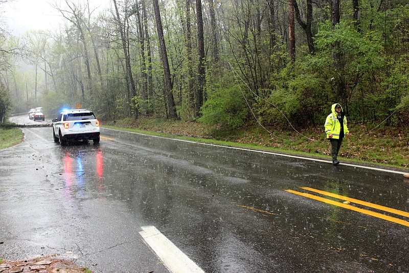 A National Park Service ranger directs traffic near downed power lines on Gorge Road at the entrance to Gulpha Gorge Campground in Hot Springs National Park on Friday. - Photo by James Leigh of The Sentinel-Record