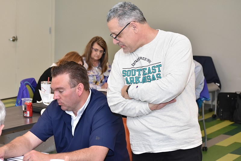 Southeast Arkansas College Athletic Director Chad Kline and President Steven Bloomberg go over group suggestions for the college's strategic plan during a board retreat Friday at the Main Library in downtown Pine Bluff. (Pine Bluff Commercial/I.C. Murrell)