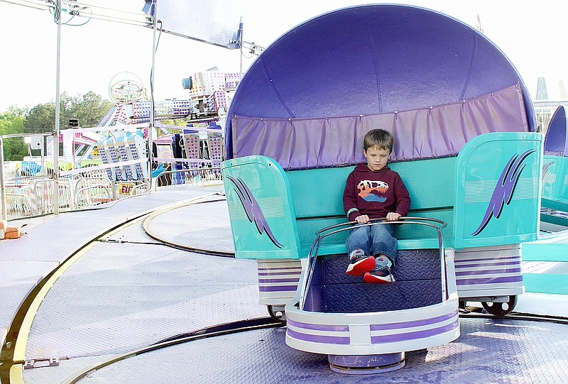 Walker Jewell, 6, of Genoa, Ark., holds onto the lap bar as the Tilt-A-Whirl begins its revolutions on the opening day of the 78th Four States Fair & Rodeo on Friday evening, March 31, 2023, in Texarkana, Ark. Walker was at the fair with his parents, Ben and Abrie Jewell. Gates open Saturday, April 1 at 10 a.m. General admission is $7 for adults and $5 for children ages 6 to 12. Armbands will be sold for unlimited rides. (Staff photo by Stevon Gamble)