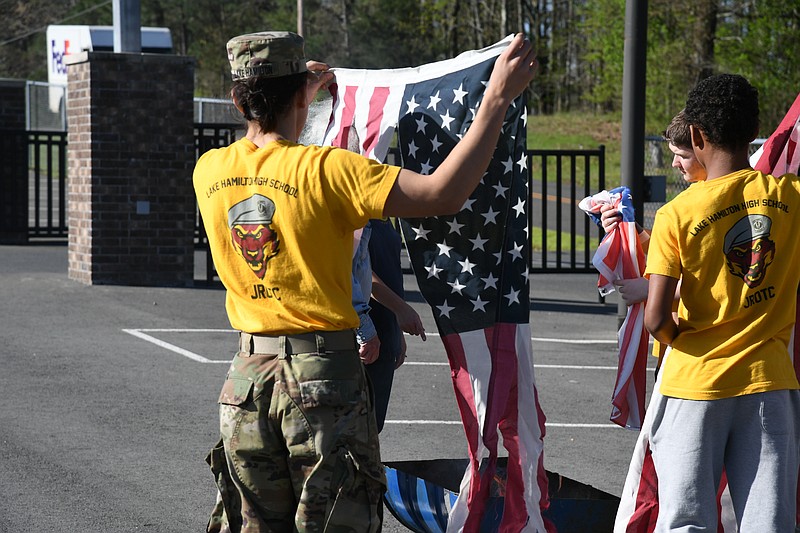 Lake Hamilton JROTC cadets prepare American flags for proper retirement on Saturday. American flags must be retired and burned once they are no longer fit to be flown or displayed. - Photo by Lance Brownfield of The Sentinel-Record.
