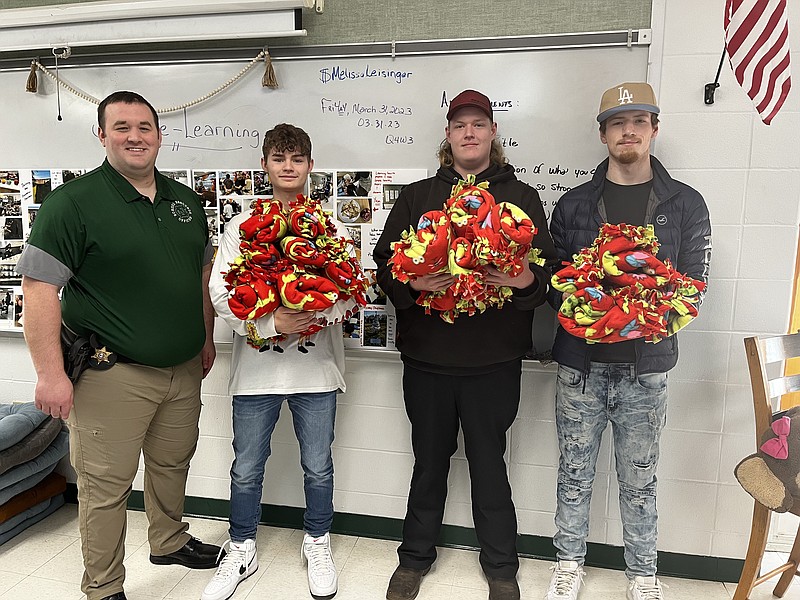 Submitted photo
Three students in the Thunderbird Academic Program at North Callaway High School present "Hug-A-Blankets" to Jon Bradley, Callaway County Sheriff's Office Deputy and North Callaway's School Resource Officer. From left to right: Jon Bradley, Skyler Riley, Dylan McCully and Landon Saxbury.