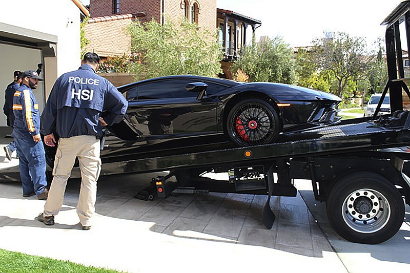 Small Business Loans-Fraud 
This photo provided by U.S. Immigration and Customs Enforcement shows special agents with HSI Los Angeles's El Camino Real Financial Crimes Task Force seize a Lamborghini from an Orange County businessman on Thursday, April 6, 2021, in Irvine, Calif. Mustafa Qadiri, 38, of Irvine, was named in a federal grand jury indictment and has pleaded not guilty to charges he obtained $5 million in federal coronavirus-relief loans for phony businesses and then used the money for lavish vacations and to buy a Ferrari, Bentley and Lamborghini, prosecutors said Monday, May 10. (U.S. Immigration and Customs Enforcement via AP)