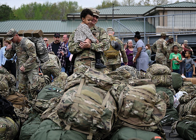 Sienna Mothershed, 3, helps her uncle, Spc. Corbin Woodward, to his bus Tuesday during a deployment ceremony for the 39th Infantry Brigade Combat Team at Camp Robinson in this April 2023 file photo. (Arkansas Democrat-Gazette/Stephen Swofford)