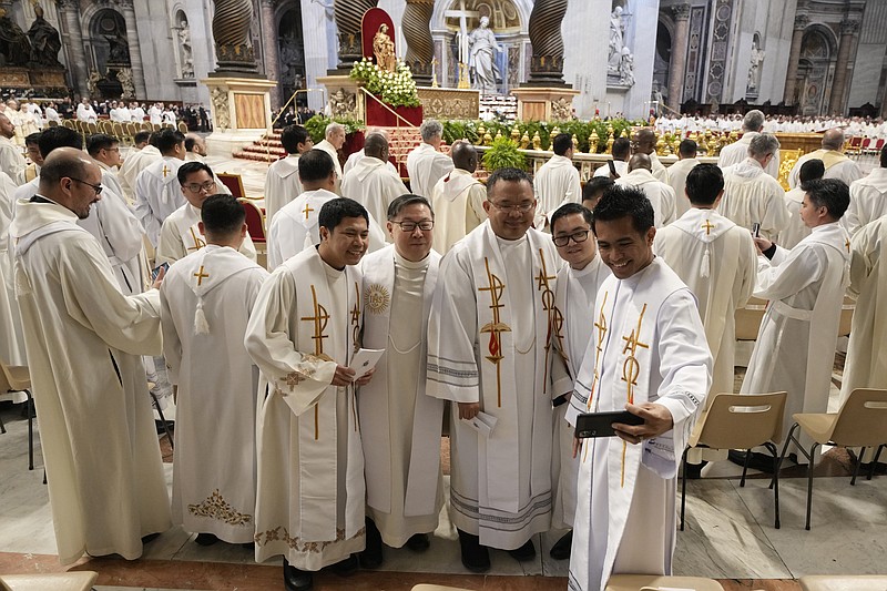 Priests take a selfie at the end of the Chrism Mass where the chrism, the oil of the catechumens and the oil of the sick are consecrated, and all the priests renew the promises made on the day of their ordination, inside St. Peter's Basilica, at the Vatican, Thursday, April 6, 2023. (AP Photo/Andrew Medichini)