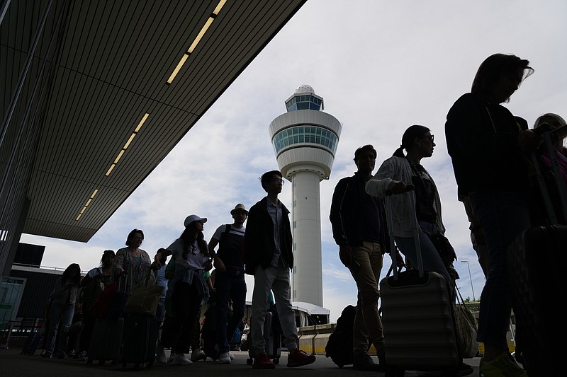 FILE - Travelers wait in long lines outside the terminal building to check in and board flights at Amsterdam's Schiphol Airport, Netherlands, on June 21, 2022. A judge ruled Wednesday April 5, 2023 that the Dutch government cannot order Amsterdam's Schiphol Airport, one of Europe's busiest aviation hubs, to reduce the number of flights from 500,000 per year to 460,000, dealing a blow to efforts to cut emissions and noise pollution.
(AP Photo/Peter Dejong, File)