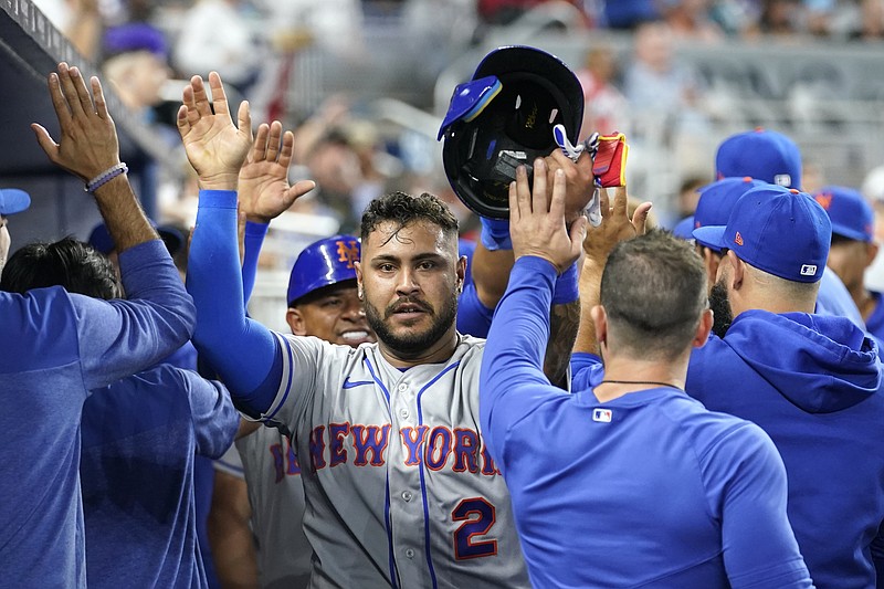 El venezolano Omar Narvéz, de los Mets de Nueva York, festeja en el dugout luego de anotar en un doble de Brandon Nimmo ante los Marlins de Miami, el jueves 30 de marzo de 2023 (AP Foto/Lynne Sladky)