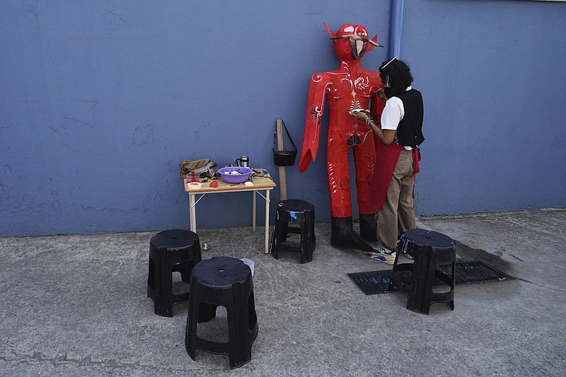 Artisan Carlos Gonzalez Aldaraca paints a devil-like cardboard figure popularly known as “Judas,” at the Santa Maria La Ribera Cultural Center in Mexico City, Thursday, April 6, 2023. During this popular activity on the sidelines of the Holy Week celebrations of the Catholic Church, people gather in neighborhoods on Holy Saturday across the country to burn cardboard symbolic embodiments of evil. (AP Photo/Marco Ugarte)