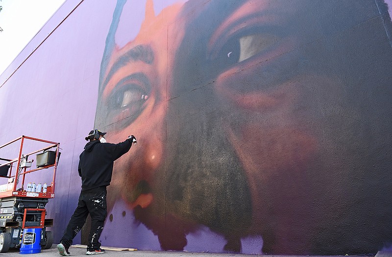 Artist Drew Merritt works on a new mural Saturday in the SoMa District of Little Rock.
(Arkansas Democrat-Gazette/Staci Vandagriff)