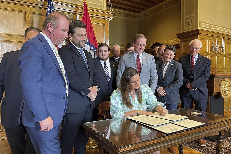 Arkansas Gov. Sarah Huckabee Sanders signs legislation at the state Capitol in Little Rock, Ark., on Monday, April 10, 2023, that will cut individual and corporate income taxes by $124 million a year. Sanders, a Republican, and legislative leaders had been advocating the tax cuts during the session that ended last week. (AP Photo/Andrew DeMillo)