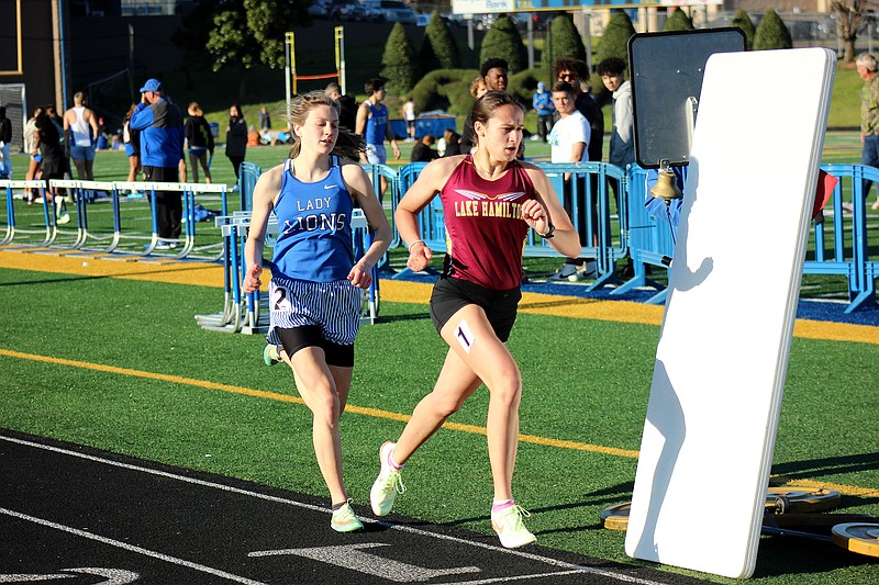 Lake Hamilton’s Olivia Pielemeier (1) finishes a lap in the 1600-meter run ahead of Jessieville’s Juliah Rodgers (2) at the Lakeside Ram Relays in 2022. - File photo by The Sentinel-Record