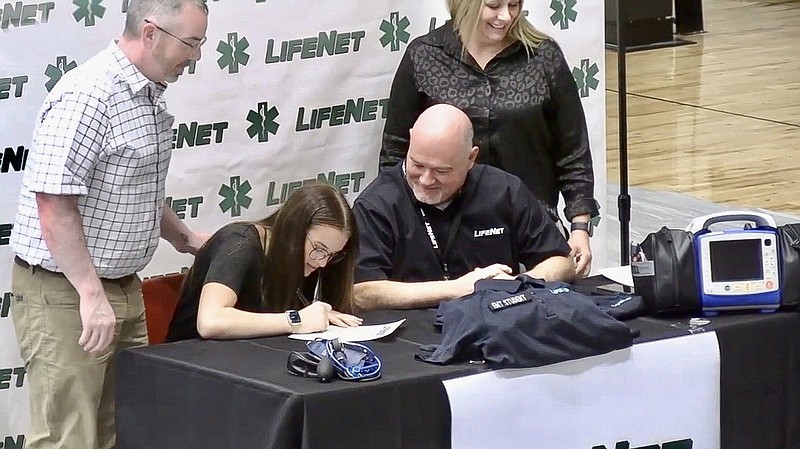 Cutter Morning Star senior Masann Hamilton signs her letter of intent to pursue a career with LifeNet Emergency Medical Services during Thursday's Signing Day event at Eagle Arena. - Photo by Lance Porter of The Sentinel-Record