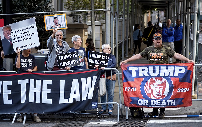 Protesters gather before former President Donald Trump arrives in a motorcade for a deposition in New York Thursday, April 13, 2023. (AP Photo/Craig Ruttle)