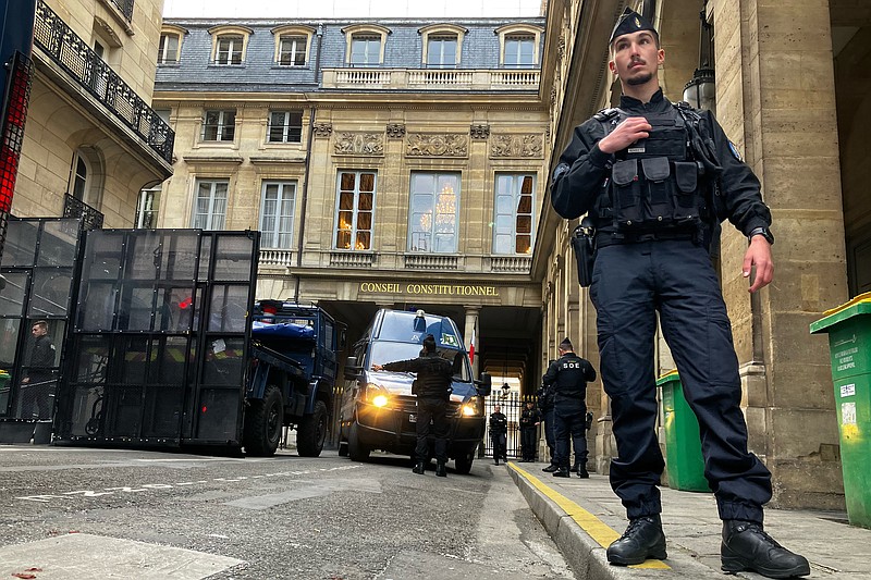 Agentes de policía montan una barricada ante el Consejo Constitucional, antes de su resolución acerca de la reforma de las pensiones aprobada por el gobierno del presidente Emmanuel Macron, en París, Francia, el 14 de abril de 2023. (AP Foto/Alexander Turnbull)