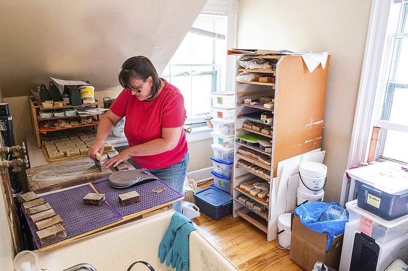 This image provided by Andrew Tolson shows Wyllow Elizabeth trimming a batch of her popular handmade mint ripple soap, which includes a blend of cocoa powder and peppermint essential oils. Elizabeth makes her soaps using various oils like olive, coconut, castor and hemp, as well as shea butter. (Andrew Tolson via AP)