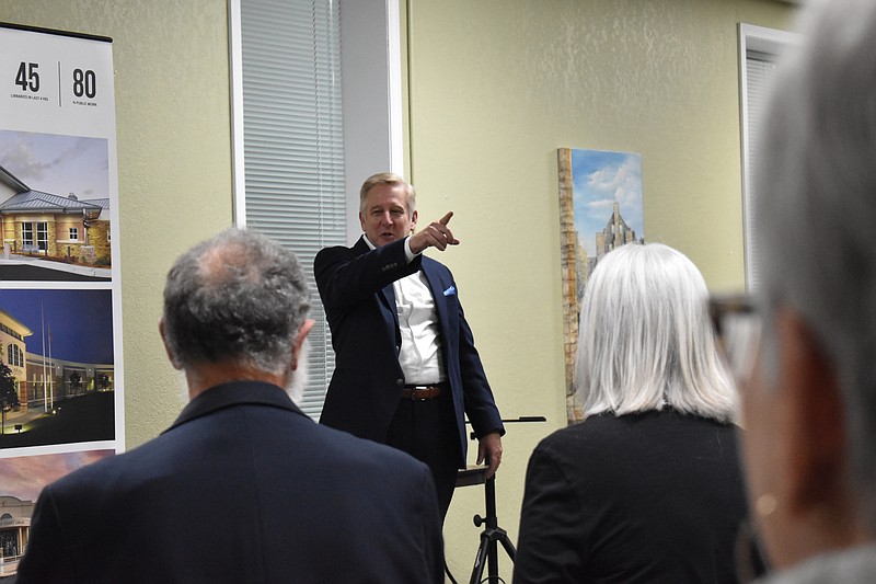 Democrat photo/Garrett Fuller — FILE — Michael Sapp, principal of Sapp Design Architects, points in the direction of the empty lot at 209 S. Oak St., that will eventually house the library's new facility as he discusses another library's unique ribbon cutting event March 21 during the library's Architect Showcase in Heyssel Hall of the Moniteau County Library at Wood Place. Sapp explained another community formed a human chain to pass books from the old facility to the new one, one at a time, like a bucket brigade.