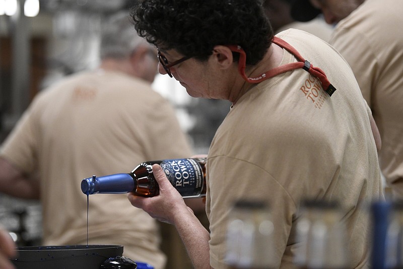 Julie Cumberland applies wax caps on the top of bottles as she helps bottle a single barrel cask strength bourbon at Rock Town Distillery on Thursday, April 13, 2023.

(Arkansas Democrat-Gazette/Stephen Swofford)
