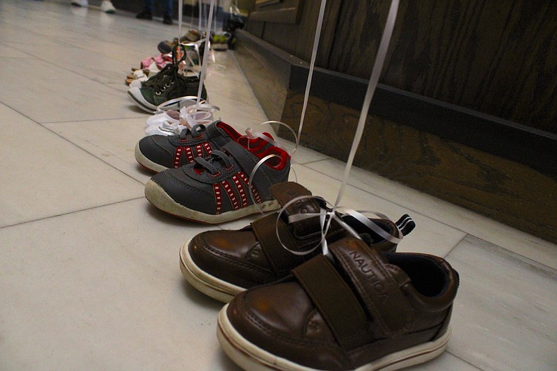 Child-sized shoes represent 13 of the 37 children killed in Arkansas by abuse in 2022. The South Arkansas Children's Coalition paid tribute to the 37 children on Friday in an event highlighting April as National Child Abuse Prevention Month. (Caitlan Butler/News-Times)