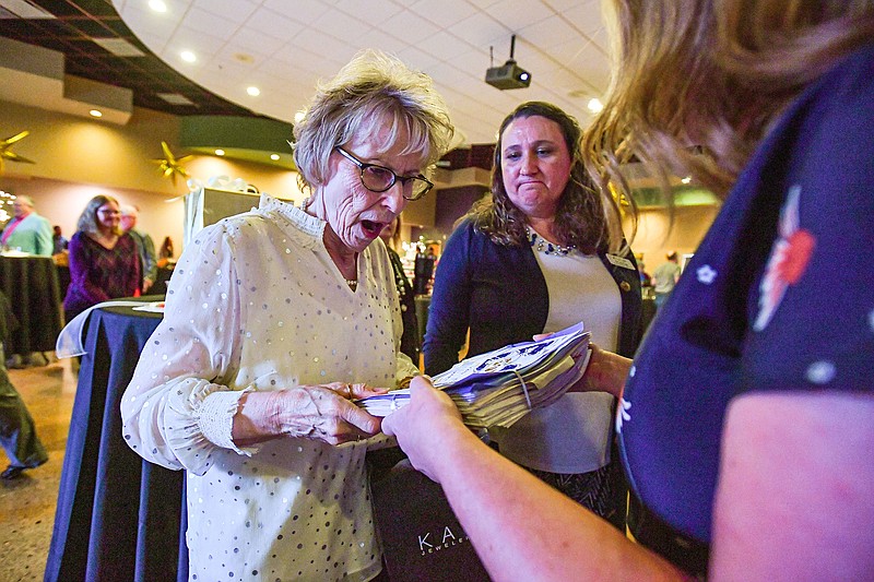 Toni Ward (left), executive director, reacts after receiving a scrapbook from colleagues Thursday at a 50th anniversary celebration of The Stepping Stone School in Alma. Stepping Stone provides services to people with intellectual and developmental disabilities and their families. Ward was also honored at the event as one of the service providers original staff members. Visit nwaonline.com/photo for today's photo gallery.
(River Valley Democrat-Gazette/Hank Layton)