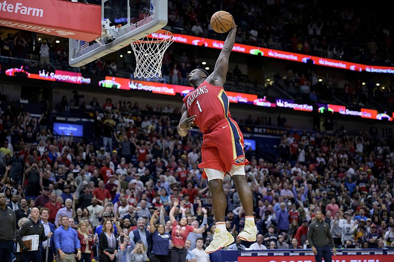 New Orleans Pelicans forward Zion Williamson (1) completes a windmill dunk against the Phoenix Suns in the second half of an NBA basketball game in New Orleans, Friday, Dec. 9, 2022. (AP Photo/Matthew Hinton)