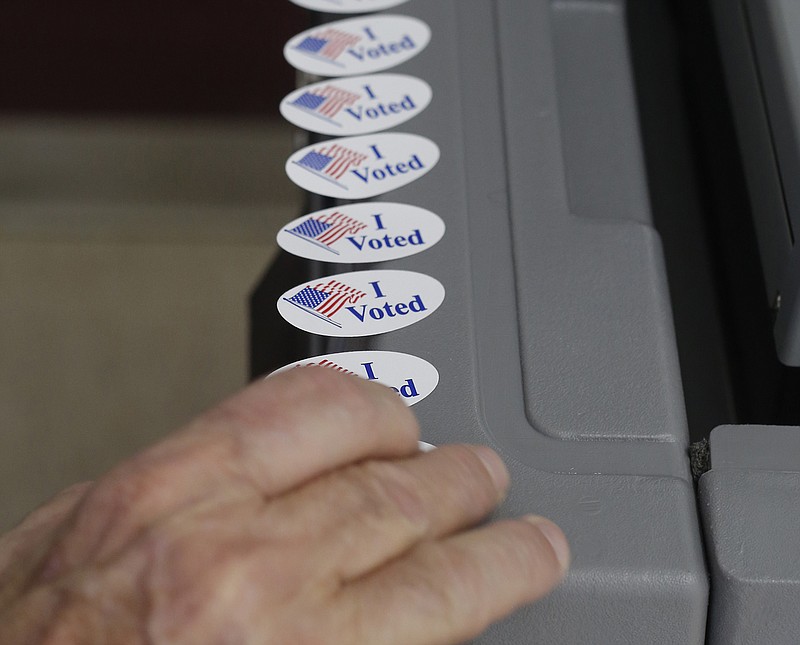 NWA Democrat-Gazette/DAVID GOTTSCHALK Bill Dudley, Washington County Election Official, arranges stickers Tuesday, May 22, 2018, on the ballot casting machine at the city of Springdale Recreation Center voting site. The Arkansas primary election took place Tuesday.