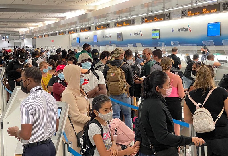 Travelers line up by the American Airline departure check in desks at Miami International Airport on Aug. 2, 2021. (Daniel Slim/AFP via Getty Images/TNS)