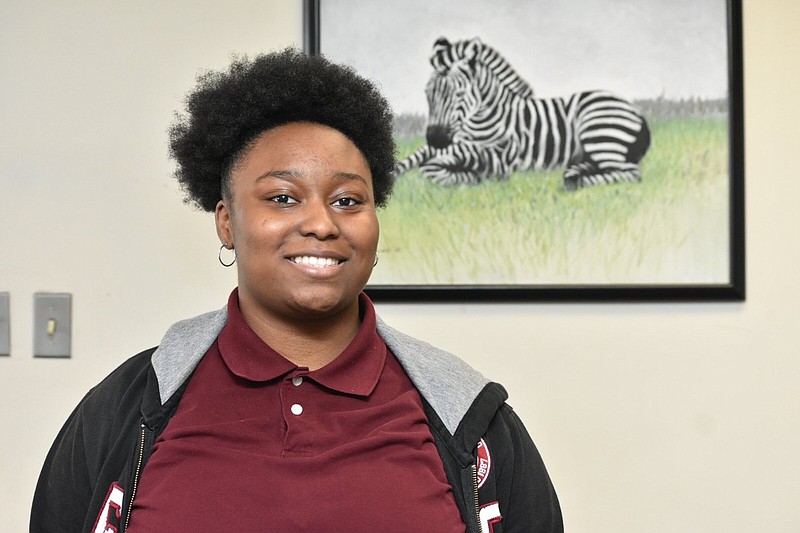 A zebra, the mascot of Pine Bluff High School, is framed over the shoulder of school valedictorian Erika Washington. (Pine Bluff Commercial/I.C. Murrell)