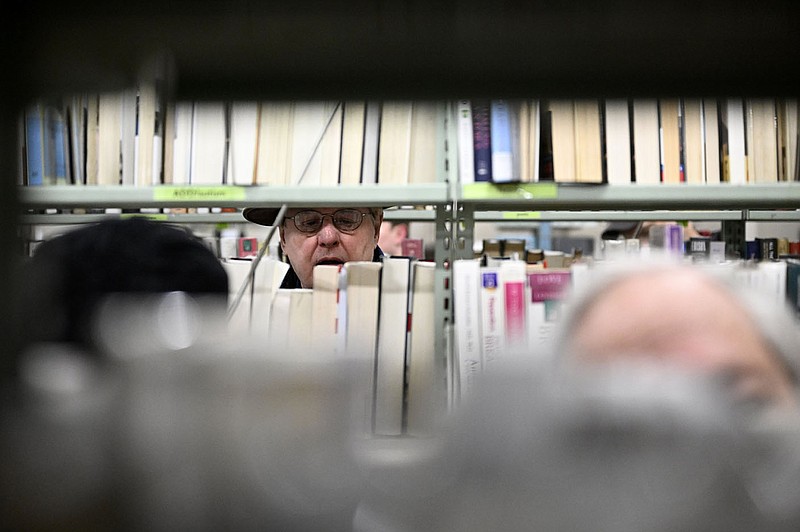 Dennis Heinitz looks through used books during the Friends of CALS Used Book Sale in the Main Library in Little Rock on Friday, March 10, 2023. Books were on sale for $1 for paperback and $2 for hardcover books.

(Arkansas Democrat-Gazette/Stephen Swofford)
