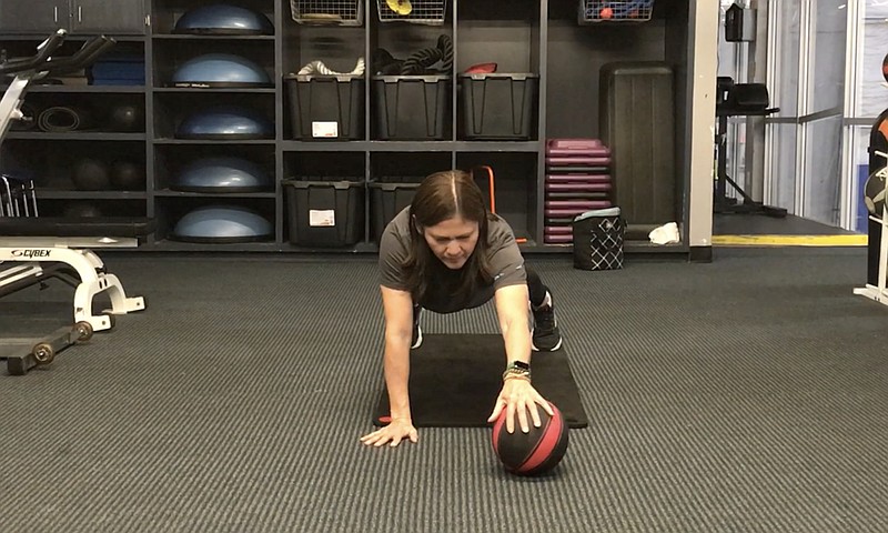 Maria Rogers, youth director at Little Rock Racquet Club, demonstrates the Plus Minus Plank exercise for Matt Parrott's Master Class. (Arkansas Democrat-Gazette/Celia Storey)