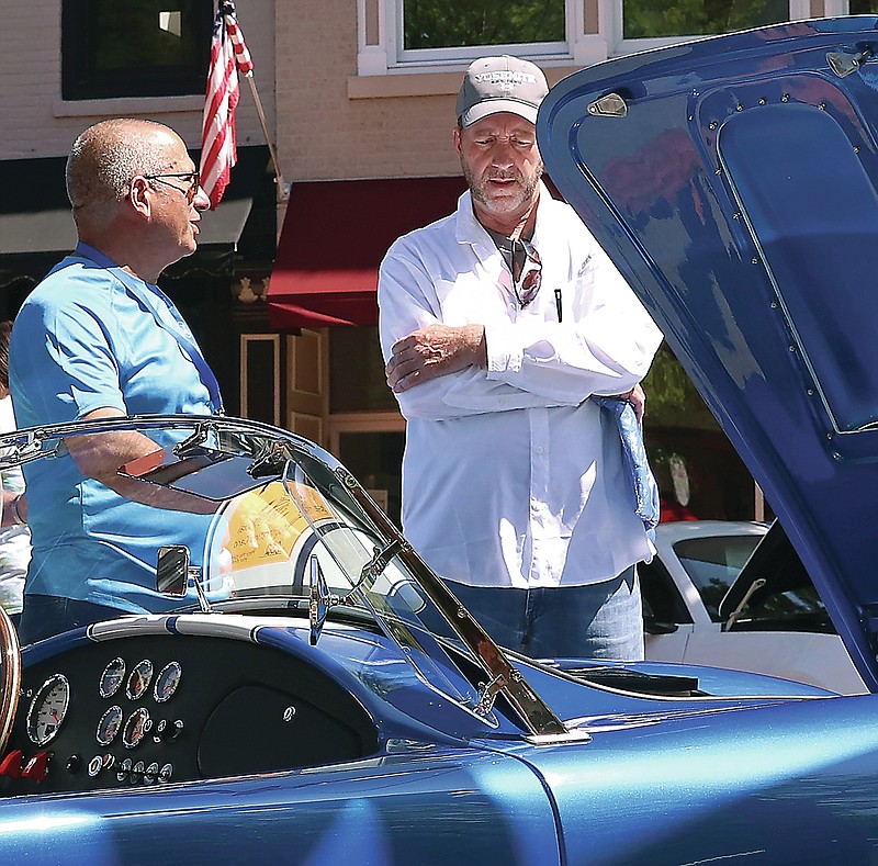 Kate Cassady/News Tribune photo: People gather at the Shelbyfest All Mustang Rally on Saturday, May 7, 2022, in downtown Jefferson City. Greg Kindel talks to a man about his car that he built from scratch just over a year ago.