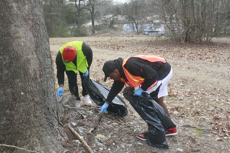 Local residents clean up trash in this News-Times file photo. A community cleanup in Ward 3 is set for Saturday, and there is still time to volunteer to participate.