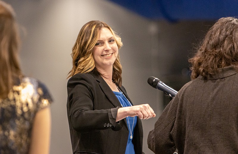 Josh Cobb/News Tribune. Head of the music department at Capital City High  School, Ashley Nelson, congratulates her students on winning the music award during Capital City High Schools student awards night on Thursday.