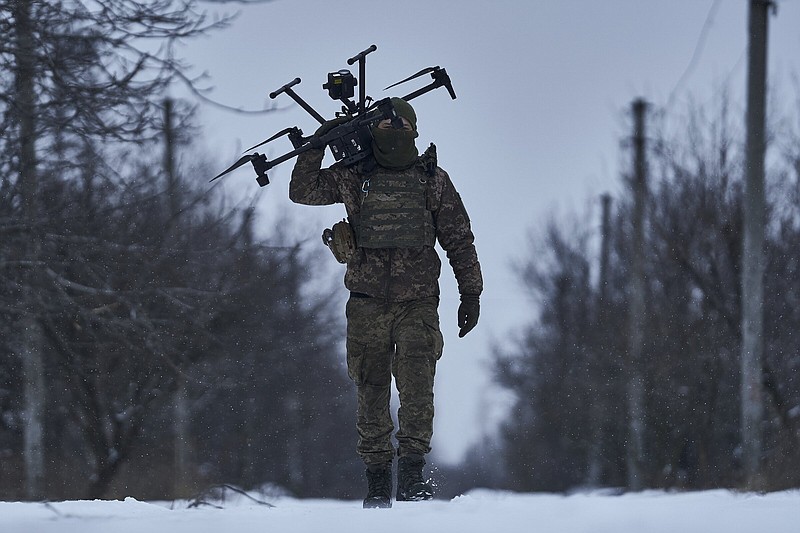 FILE -  A Ukrainian soldier carries a drone close to the frontline near Avdiivka, Donetsk region, Ukraine, Friday, Feb. 17, 2023. Ukrainian government is launching a new initiative meant to streamline and promote innovation on drones and other technologies that have become critical in the country's fight against Russia, by bringing together state, military, and private sector developers working on defense issues. (AP Photo/Libkos, File)