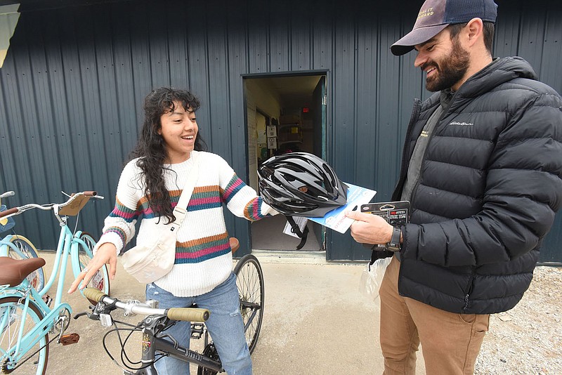 BICYCLES SPOKEN HERE
Lynette Castro of Bentonville gets a helmet on Saturday Jan. 7 2023 from Kenny Williams, executive director at Pedal It Forward bicycle organization, after Castro received a bike at the Pedal It Forward workshop on Wishing Spring Road in Bentonville. Pedal It Forward volunteers spuce up new or used donated bikes and distributes them free or for a donation. "Everyone deserves a bike," is the group's motto. Go to nwaonline.com/photos for today's photo gallery.
(NWA Democrat-Gazette/Flip Putthoff)