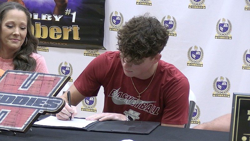 Senior guard Colby Lambert signs his letter of intent to play college basketball Tuesday at Fountain Lake's Bass Gym. Lambert scored over 1,000 points in his high school career and will suit up for the Henderson State Reddies. - Photo by Lance Porter of The Sentinel-Record