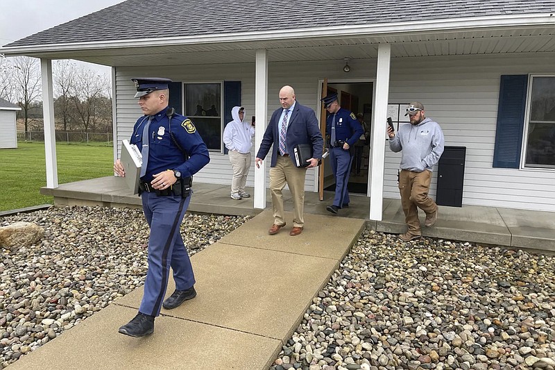 FILE - The Michigan State Police exit the Adams Township Hall after executing a search warrant, Oct. 29, 2021 in Hillsdale, Mich. The search warrant was part of an investigation into actions by Clerk Stephanie Scott who has been stripped of her role in future elections. Voters in one of Michigan's most conservative counties on Tuesday, May 3, 2023, ousted Scott accused of improperly handling voting equipment after casting doubt on President Joe Bidens election victory. (Corey Murray/Hillsdale Daily News via AP, File)