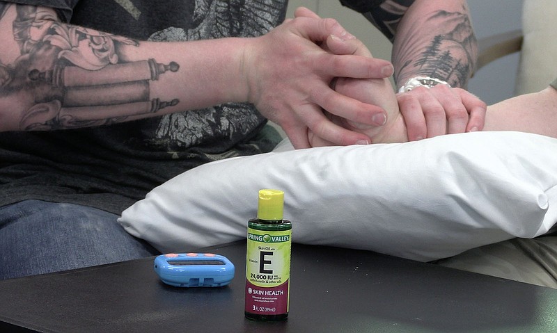 John Roach gives one of his patients a hand massage during his visit to Hot Springs Hand Therapy. – Photo by Courtney Edwards of The Sentinel-Record