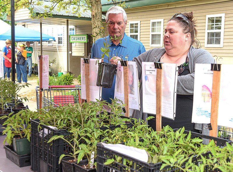 Julie Smith/News Tribune
Jen Maurer, right, and Doug Galloway made their way to the tomato plants first thing Friday at the Central Missouri Master Gardeners Plant Sale at the greenhouses in north Jefferson City. Both are fans of the sale and attend early opening day to have a chance at the best selection possible. They were among the first wave who were waiting in line when the gate opened at 9 a.m. The sale will resume at 8 a.m. Saturday and continue until noon.