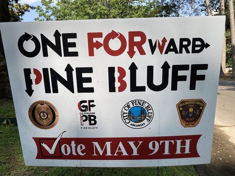 An image of a Pine Bluff Police Department badge (left) and of a patch worn by city firefighters (right) adorn campaign signs in support of the Go Forward Pine Bluff-sponsored tax vote, even though neither of the two fraternal orders in those departments has endorsed the proposed taxes. (Pine Bluff Commercial/Byron Tate)