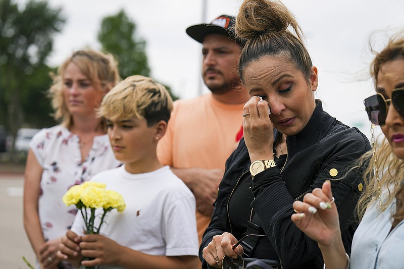 Sara Tabatabaie wipes away a tear at a memorial outside an entrance to the parking lot of the mall a day after a mass shooting at Allen Premium Outlets on Sunday, May 7, 2023, in Allen, Texas. (Smiley N. Pool/The Dallas Morning News via AP)