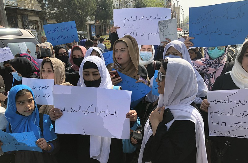 FILE - Afghan women chant and hold signs of protest during a demonstration in Kabul, Afghanistan, March 26, 2022. A U.N. report on Monday, May 8, 2023 condemned the Taliban for their harsh rule since seizing power in Afghanistan — including public execution, lashings, and amputations — and for ignoring international calls to respect human rights and freedoms. (AP Photo/Mohammed Shoaib Amin, File)