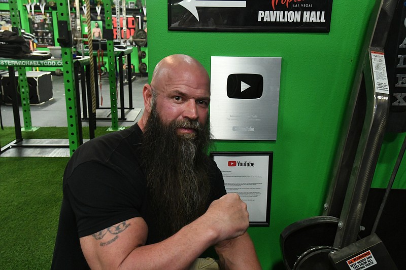 Monster Michael Todd, the largest arm wrestling influencer in America, poses with his YouTube Play Button that he earned for gaining more than 100,000 subscribers on the platform. - Photo by Lance Brownfield of The Sentinel-Record.