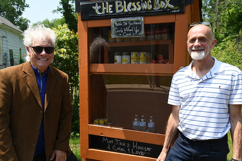 Local magician Maxwell Blade, left, installed this blessing box last Friday at 108 Palmetto St. with Tim Looper, the administrator for Healing Outreach Ministry of Equality. - Photo by Lance Brownfield of The Sentinel-Record