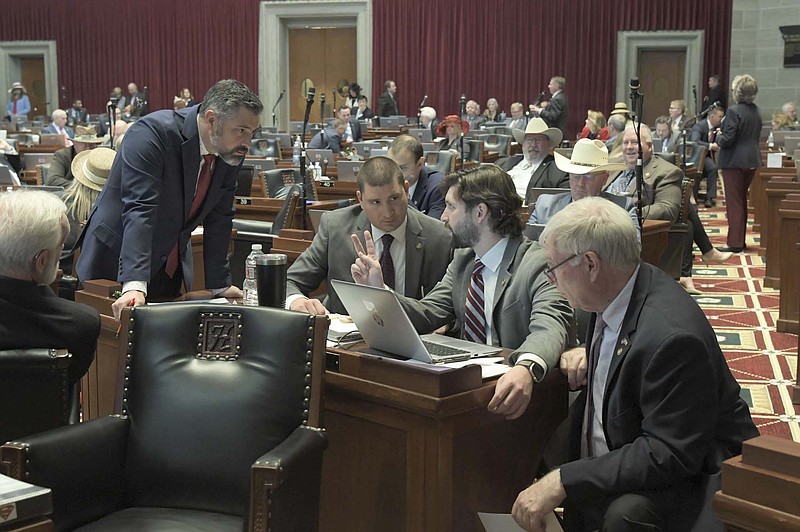 State Rep. Ben Baker, R-Neosho, Rep. Tony Lovasco, R-O'Fallon, Rep. Bishop Davidson, R-Republic, and Rep. Jim Murphy, R-St. Louis, discuss legislation on the Missouri House floor on May 4, 2023. Davidson was able to shepherd some education legislation to the governor's desk. (Submitted photo courtesy of Tim Bommel, House Communications)