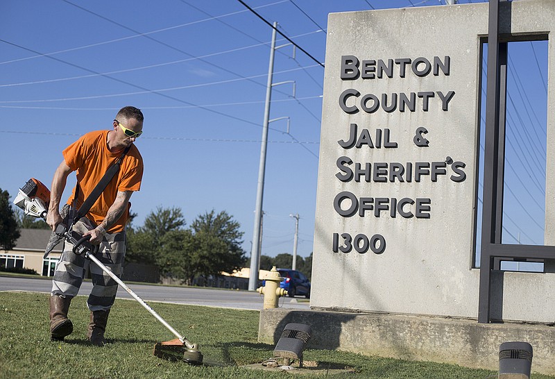 Ryan Smith maintains a lawn Sept. 30, 2019, at the Benton County Jail in Bentonville. Benton County justices of the peace heard a presentation Tuesday concerning heating and air conditioning issues at the county jail.
(NWA Democrat-Gazette/Charlie Kaijo)
