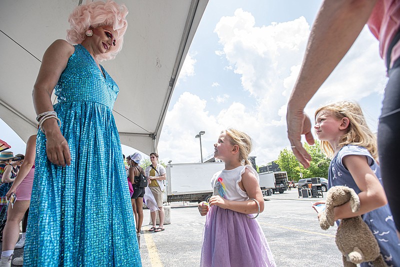 Taylor Madison Monroe (from left), 2018 Miss Gay Arkansas America first alternate, visits with Elisabella Brown, 5, of Fayetteville and Caroline Bairds, 4, of Maumelle on June 18, 2022, at the 2022 Northwest Arkansas Pride Weekend in the Walton Arts Center parking lot in Fayetteville. NWA Equality said in a news release Wednesday that the Walton Arts Center has declined to serve as a venue for any drag performances where youth are permitted to attend, and that the festival's youth programs will happen at the Fayetteville Town Center instead. (File photo/NWA Democrat-Gazette/Hank Layton)