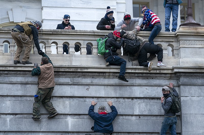 FILE - Rioters loyal to President Donald Trump climb the west wall of the the U.S. Capitol, Jan. 6, 2021, in Washington.  (AP Photo/Jose Luis Magana, File)