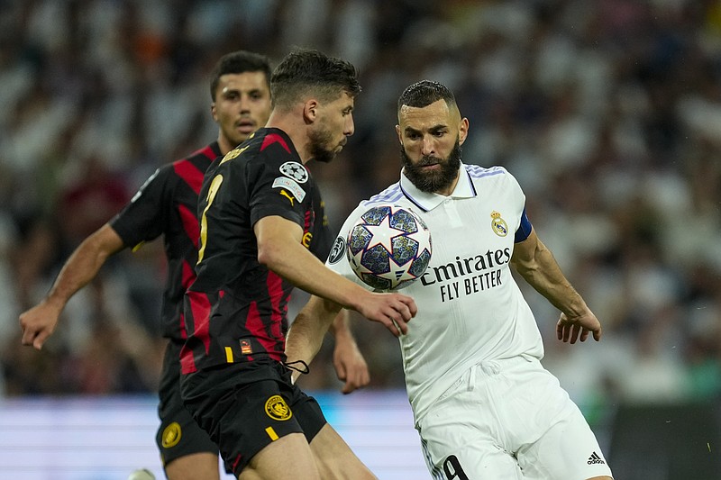 En foto del 9 de mayo del 2023, Karim Benzema del Real Madrid pelea por el balón con Ruben Dias del Manchester City en el encuentro de la Liga de Campeones. El viernes 12 de mayo del 2023, anuncian una serie de encuentros amistosos en EE.UU. que incluirá una edición del clásico entre el Madrid y Barcelona en julio. (AP Foto/Jose Breton)