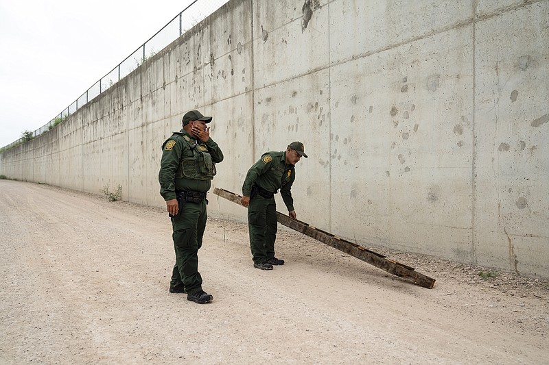 ARCHIVO - Agentes de la Patrulla Fronteriza retiran una escalera usada por migrantes para cruzar un muro cerca del cruce fronterizo de Hidalgo, Texas, el 4 de mayo de 2023. (AP Foto/Veronica G. Cardenas, archivo)